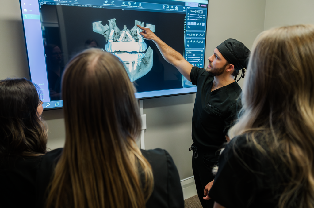 Dr. Henley showing staff model of patent's mouth