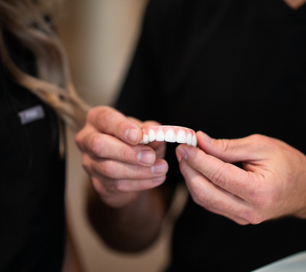 Dentist showing model of upper teeth